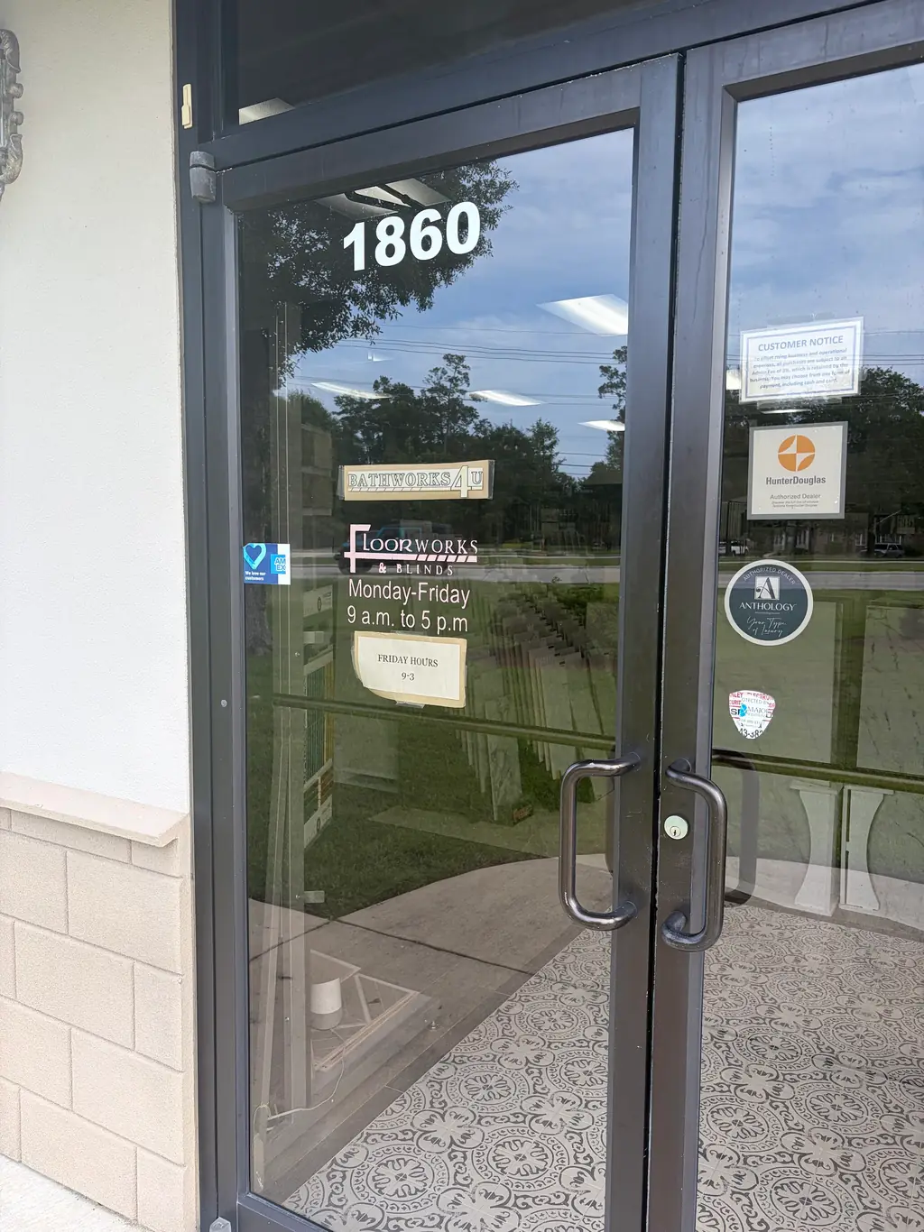 The Bathworks4U showroom door in Slidell, with the BathWorks4U decal beside Hunter Douglas and Anthology authorised dealer decals and the posted opening hours